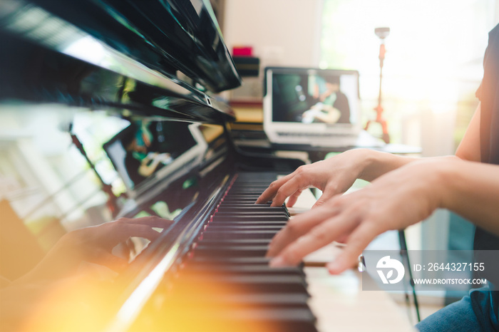 Scene of piano lessons online training or E-class learning while Coronavirus spread out or covid-19 crisis situation, vlog or teacher make online piano lesson to teach students pupils learn from home.