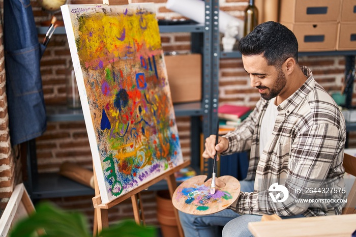 Young hispanic man smiling confident drawing at art studio