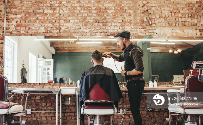 Hairstylist cutting hair of male customer