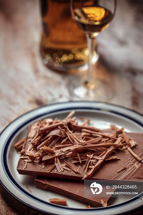 A glass of cognac, brandy or whiskey and grated pieces of chocolate bar