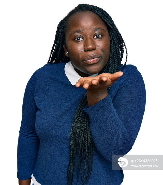 Young black woman with braids wearing casual clothes looking at the camera blowing a kiss with hand on air being lovely and sexy. love expression.