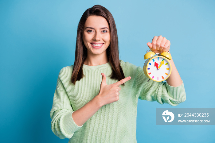 Photo of positive girl point index finger clock wear green sweater isolated over blue color background