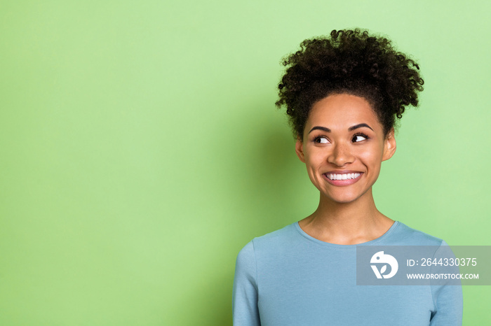 Photo of dreamy sweet lady dressed blue shirt smiling looking empty space isolated green color background