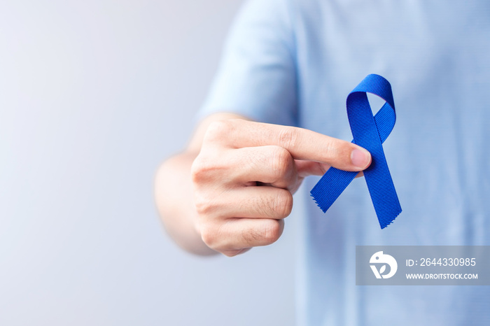 March Colorectal Cancer Awareness month, Woman holding dark Blue Ribbon for supporting people living and illness. Healthcare, hope and World cancer day concept