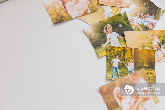 printed photos of family summer vacation lying on desk.