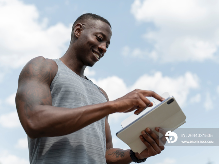 Smiling man using digital tablet outdoors