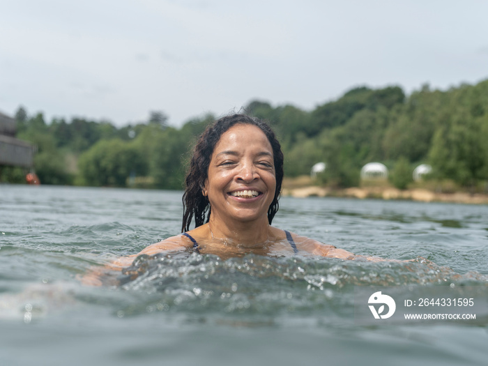 Portrait of smiling woman swimming in lake