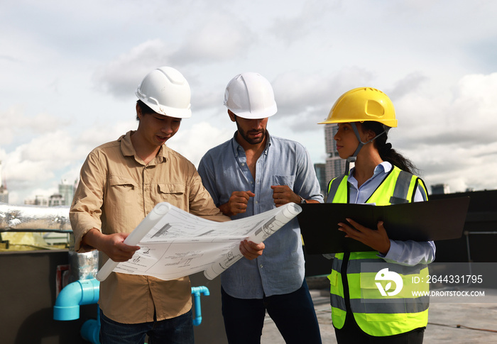 Chief engineer and site engineer working together on rooftop of new  building. Project engineer team discussing on the drawing at site line