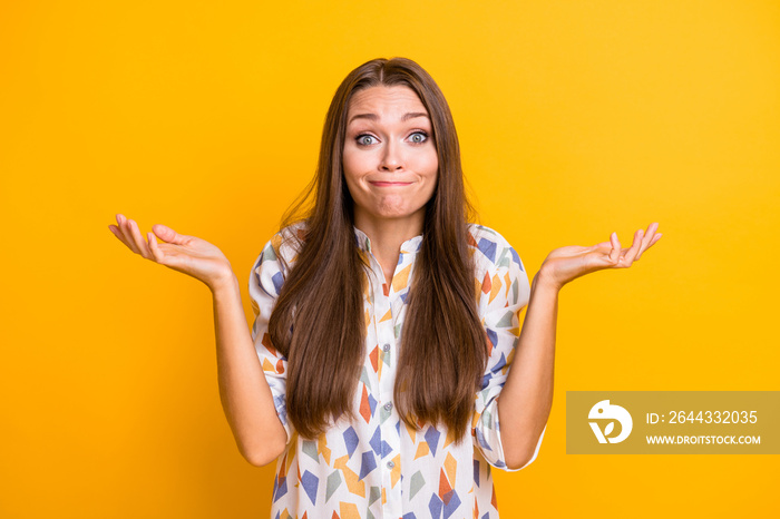 Photo of young attractive woman shrug shoulders clueless confused no answer decide isolated over yellow color background