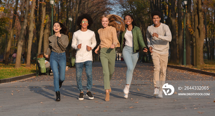 Crazy teens running towards camera, park background