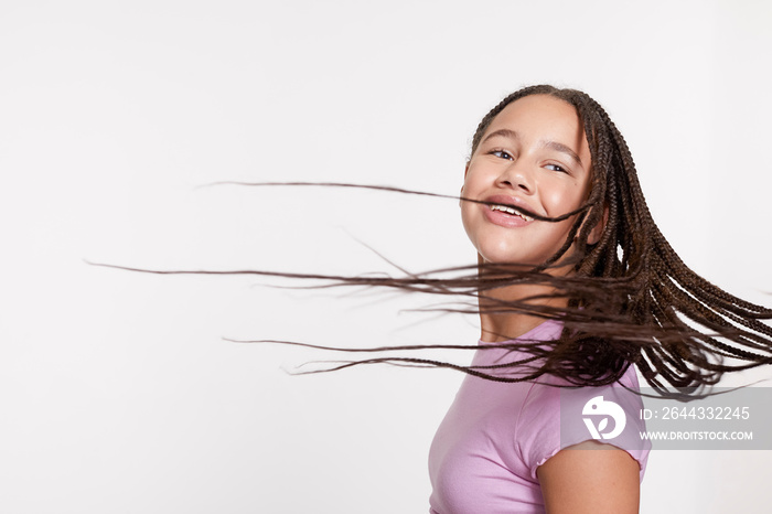 Studio portrait of smiling girl with long braided hair