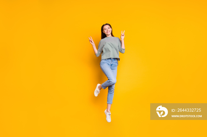 Full length body size photo of cheerful amazing gorgeous girlfriend wearing jeans denim trousers and showing you v-sign while isolated with yellow vivid background