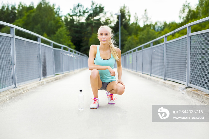 Smiling female runner taking a break after running