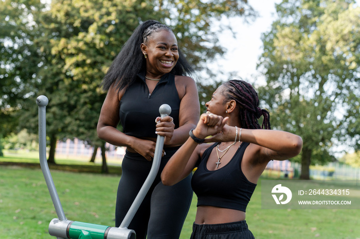 Young female friends exercising in outdoor gym