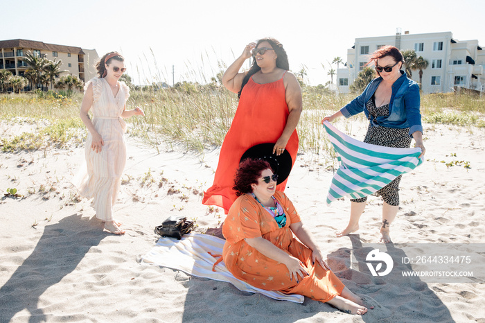 4 friends sit down at the beach