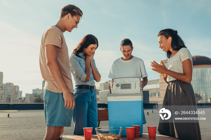 friends looking at portable fridge