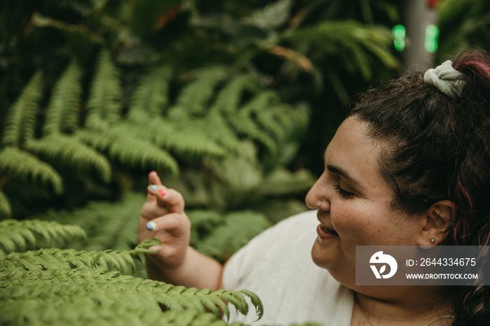 closeup of a plus size Jewish woman smiling and looking at plants