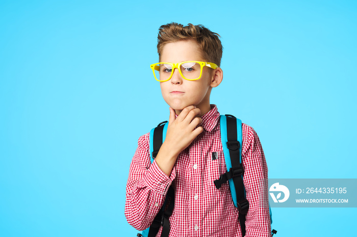 Puzzled by schoolchildren with a backpack on their back and yellow glasses