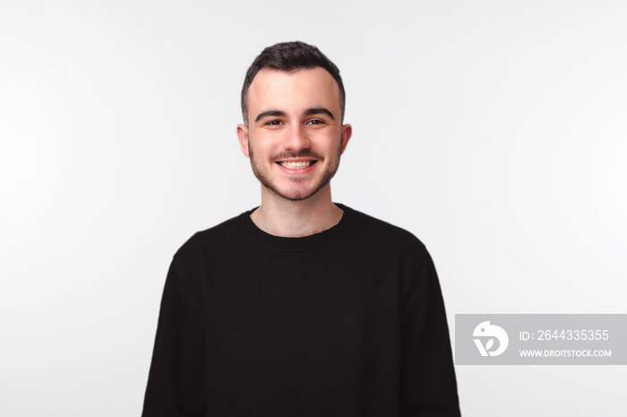 Portrait of cheerful smiling man standing over white wall