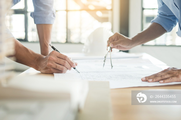 Close-up Of Person’s engineer Hand Drawing Plan On Blue Print with architect equipment, Architects discussing at the table, team work and work flow construction concept