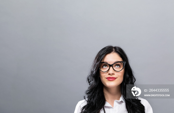 Young woman looking upward on a solid background