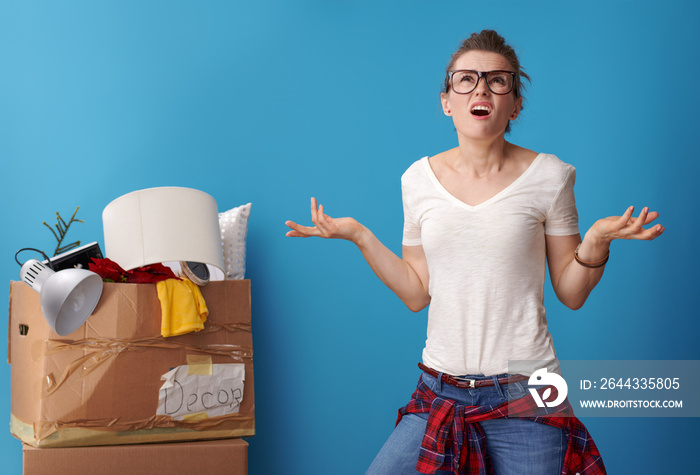 woman with an untidy cardboard box in the background looking up