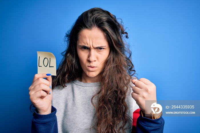 Young beautiful woman with curly hair holding reminder paper with lol message annoyed and frustrated shouting with anger, crazy and yelling with raised hand, anger concept