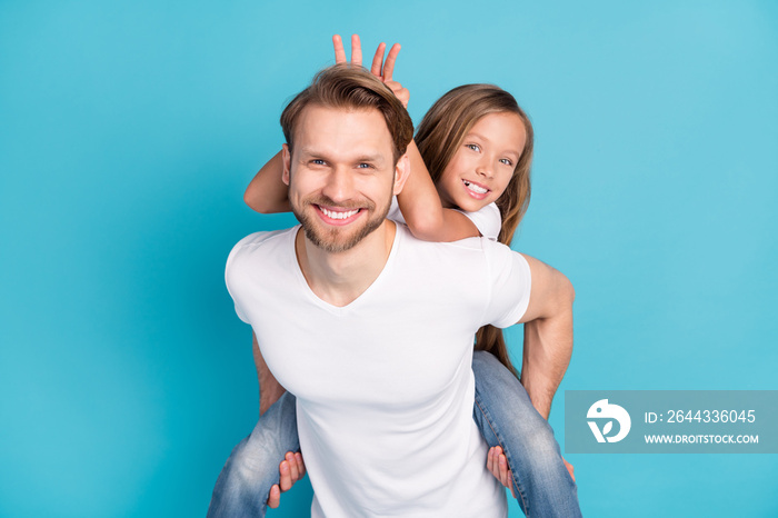 Photo of positive man hold on back piggyback cheerful girl fingers show horns dad head isolated on blue color background