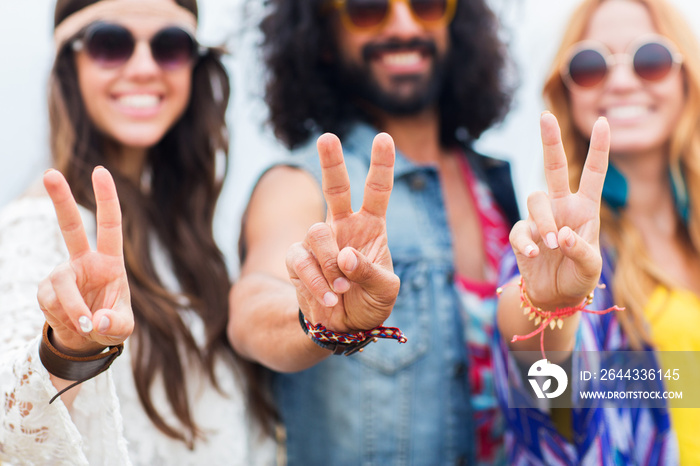 happy young hippie friends showing peace outdoors