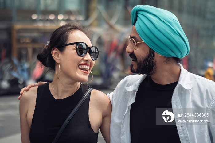 Close up of mix raced happy couple walking and embracing outdoors