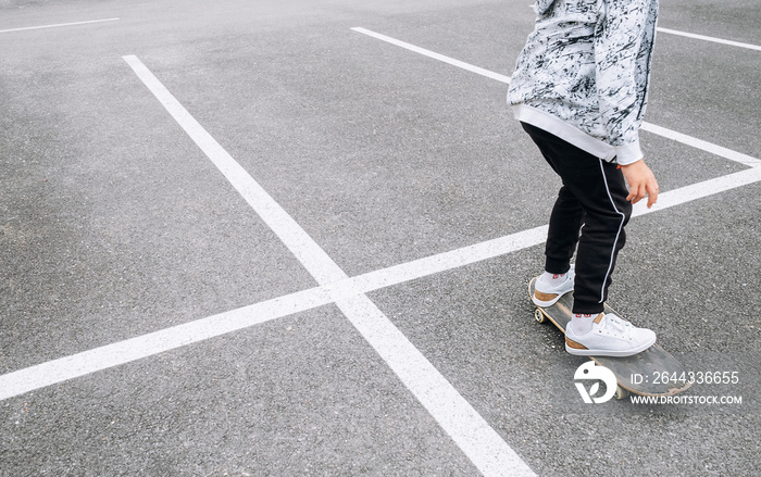 Teenager skateboarder boy with a skateboard on asphalt playground doing tricks. Youth generation Freetime spending concept image.