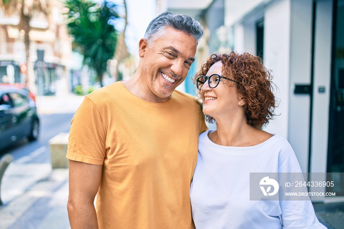 Middle age couple smiling happy standing at street of city.