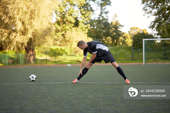 soccer player stretching leg on field football