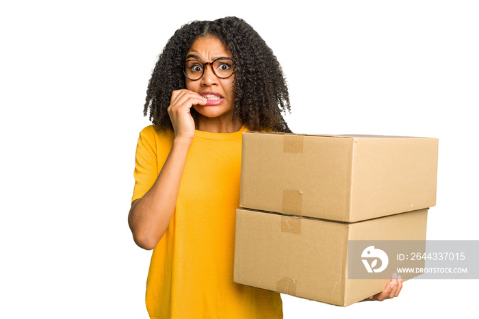 Young african american woman moving to other house while picking up a box full of things isolated biting fingernails, nervous and very anxious.