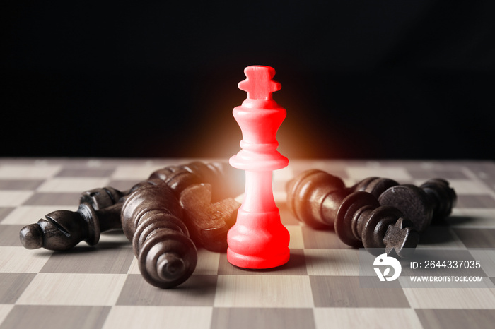 Red chess piece among ordinary ones on checkerboard against dark background