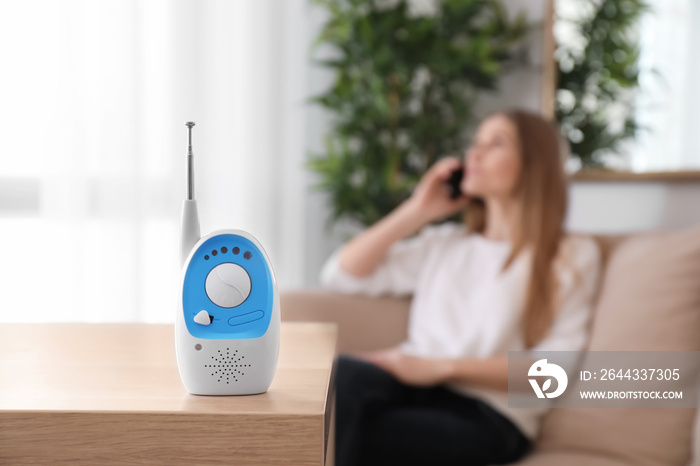 Baby monitor and woman on background. Radio nanny