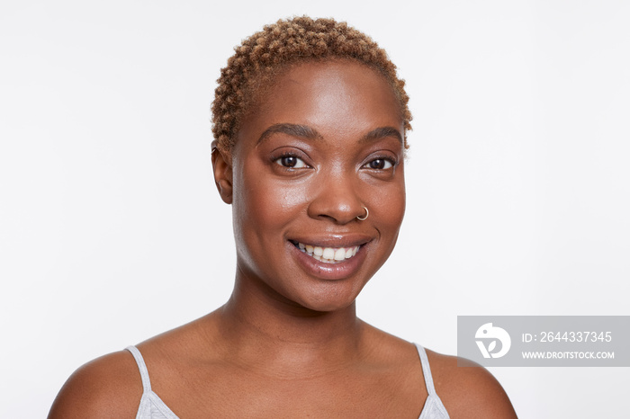 Studio portrait of smiling woman with nose ring