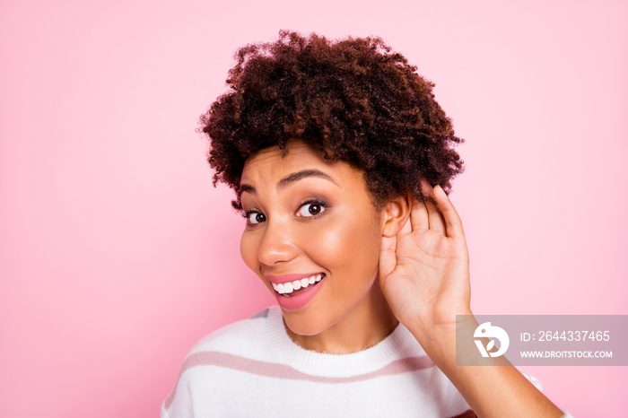 Close up photo of curly trendy cute sweet charming darkish skinned lady smiling toothily eavesdropping talks with cheerful unexpected facial expression isolated pink pastel color background