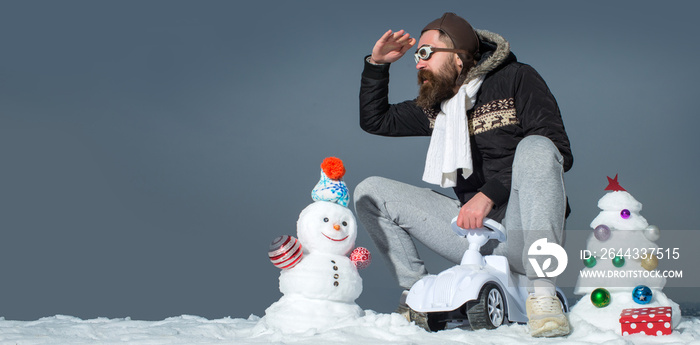 Crazy winter man on bicycle outdoor. Man with snowman on winter outdoor background. Snow man for winter banner.