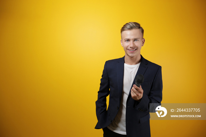 Young presenter with microphone on color background