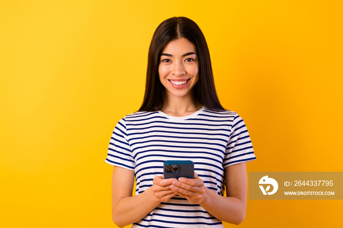 Portrait of pretty positive person toothy smile hold use telephone chatting isolated on yellow color background