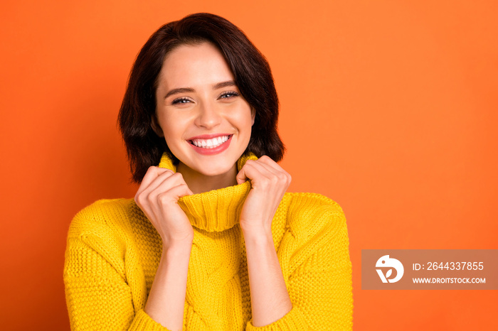 Close up photo of charming gorgeous woman being photographed wearing yellow sweater while isolated with orange background