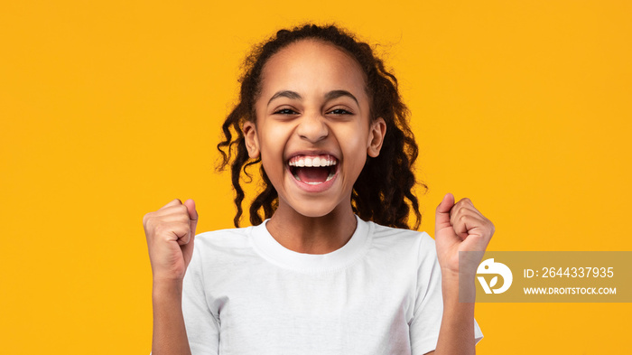 Portrait of emotional black girl screaming with raised fists