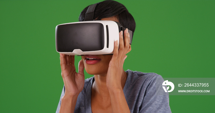 Black female using virtual reality headset on green screen