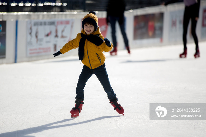 Happy boy with hat and jacket, skating during the day, having fun .