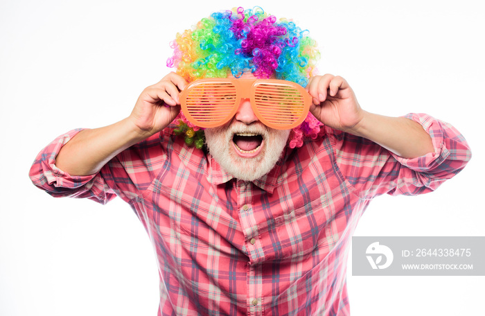 Man senior bearded cheerful person wear colorful wig and sunglasses. Elderly clown. Having fun. Funny lifestyle. Fun and entertainment. Comic grandfather concept. Nice joke. Grandpa always fun