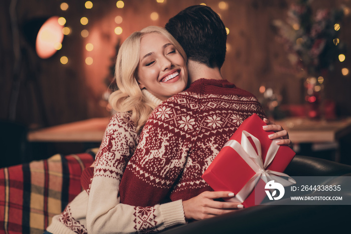 Photo of excited adorable wife husband dressed print pullovers getting christmas gift smiling indoors room home house