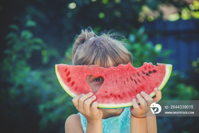 The child eats watermelon in summer. Selective focus.