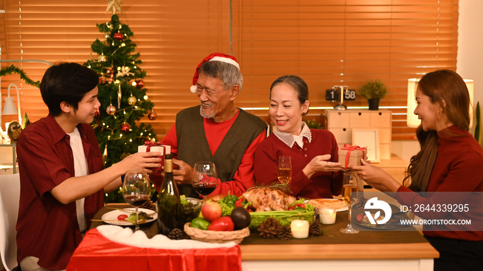 Image of happy family celebrating Christmas together at home lighted with soft lights and candles. Celebration, holidays and people concept