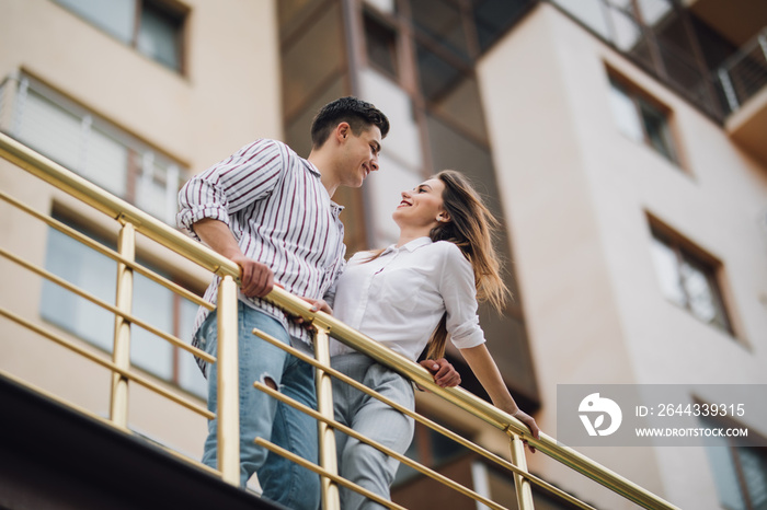 Lovely happy couple relax and have fun at balcony in their new home apartment